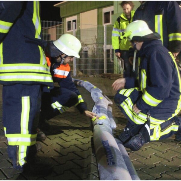 Feuerwehrleute prüfen den Floodworx Wasserschutzschlauch und sind von den Vorteilen überzeugt.