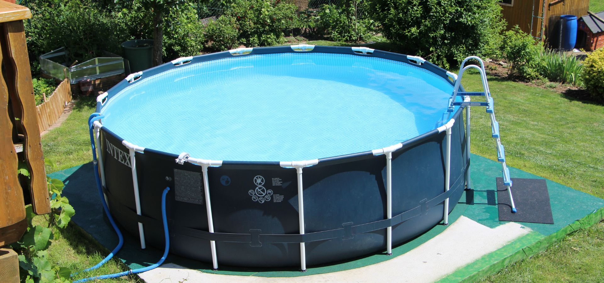 Mit Wasser gefüllter runder Stahlrahmenpool im Garten.