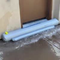 Floodworx Wasserschutzschlauch schützt eine Kellertüre vor drohendem Wasser.